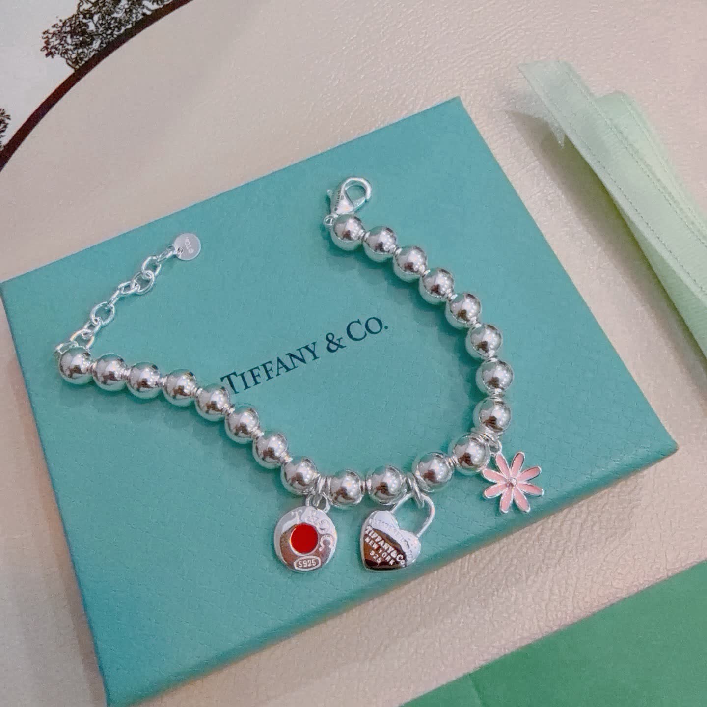 Tiffany & Co. Sterling Silver Bead Bracelet with Lock and Flower Charms